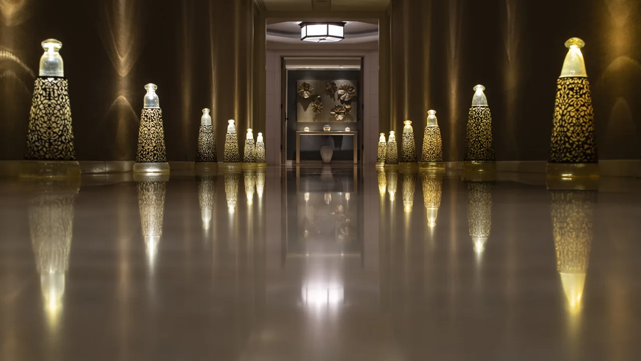 Parlak zemin ve simetrik girişe sahip aydınlatılmış otel lobisi