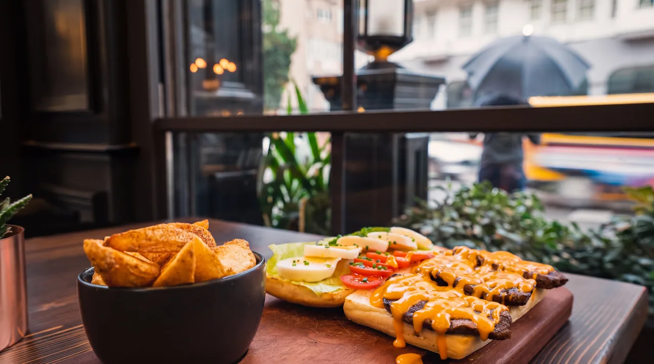 Aydınlık restoran penceresi yanında sandviç ve patates kızartması